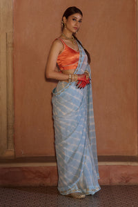 Neelima – Sky Blue Leheriya Saree with Orange Sleeveless  Blouse