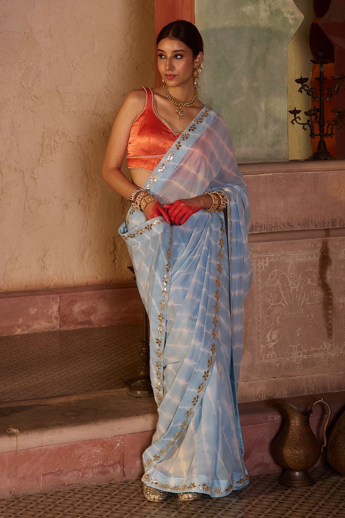 Neelima – Sky Blue Leheriya Saree with Orange Sleeveless  Blouse